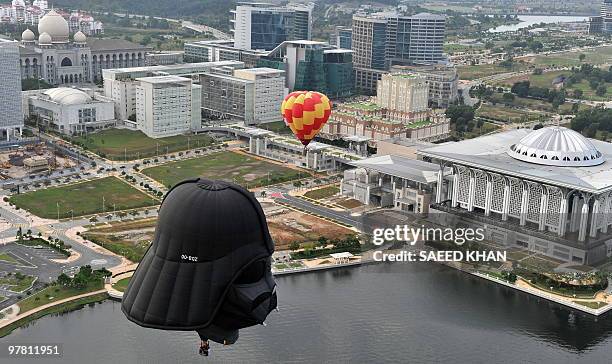 Hot air balloons, including one shaped like the head of the character Darth Vader from the Star Wars films, fly over Malaysia's administrative...