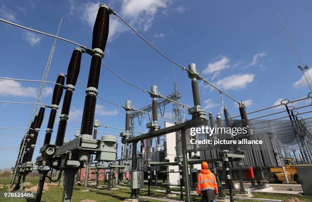 April 2018, Germany, Bentwisch: A staff member of grid operator 50Hertz walks through the large switchboard unit at the new transformer substation....