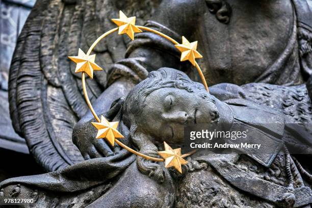 statue of a christ figure wearing a gold halo with five stars and held by an angel - st vitus's cathedral stock pictures, royalty-free photos & images