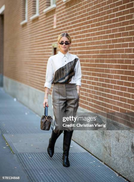 Caroline Daur wearing black boots, Fendi bag, button shirt is seen outside Fendi during Milan Men's Fashion Week Spring/Summer 2019 on June 18, 2018...