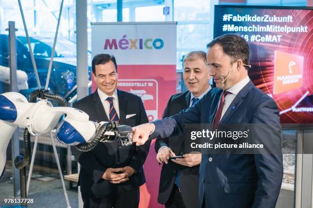 April 2018, Hanover, Germany: Jochen Köckler, CEO of Deutsche Messe AG , acts with a robot hand during a press conference on the Hanover Fair and the...