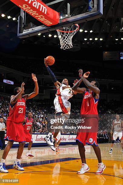 Anthony Morrow of the Golden State Warriors shoots a layup against Thaddeus Young and Samuel Dalembert of the Philadelphia 76ers during the game at...