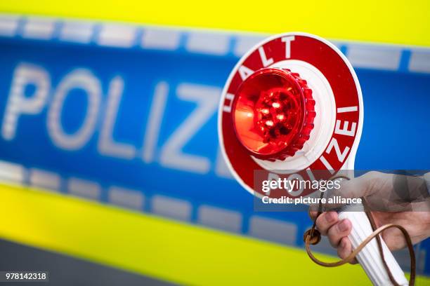 April 2018, Germany, Moenchengladbach: A police officer holds up a police stop sign reading 'Halt Polizei' during a press event. Photo: Marius...