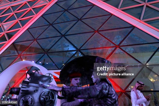 Dpatop - Two men in costume welcome visitors during the opening of the AMC Entertainment cinema theatre at the King Abdullah Financial District in...