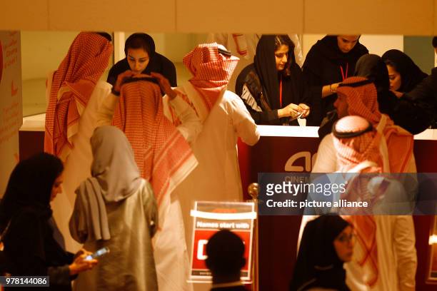 Saudi moviegoers buy tickets at the box office during the opening of the AMC Entertainment cinema theatre at the King Abdullah Financial District in...