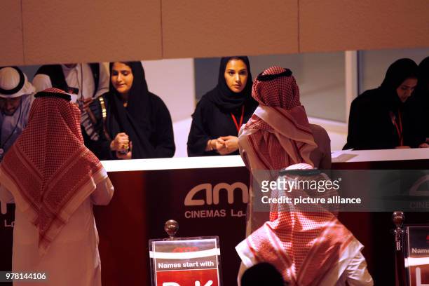 Saudi moviegoers buy tickets at the box office during the opening of the AMC Entertainment cinema theatre at the King Abdullah Financial District in...