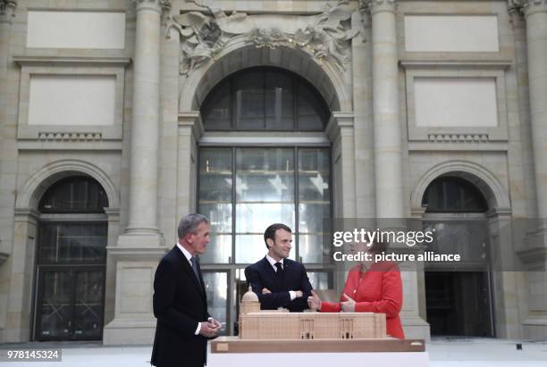 April 2018, Germany, Berlin: German Chancellor Angela Merkel and French President Emmanuel Macron visit the foyer of the Humboldt Forum in the Berlin...