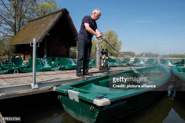 April 2018, Seeburg, Germany: Ulrich Jung, boat hirer at Seeburger Lake, cleaning a pedalo. The pedalo and outside swimming pool season is starting...