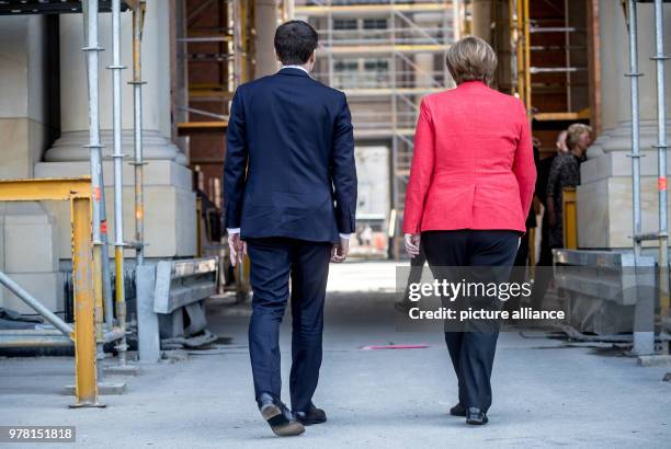 German Chancellor Angela Merkel receives French President Emmanuel Macron at the Humboldt Forum in the Berlin Palace, in Berlin, Germany, 19 April...