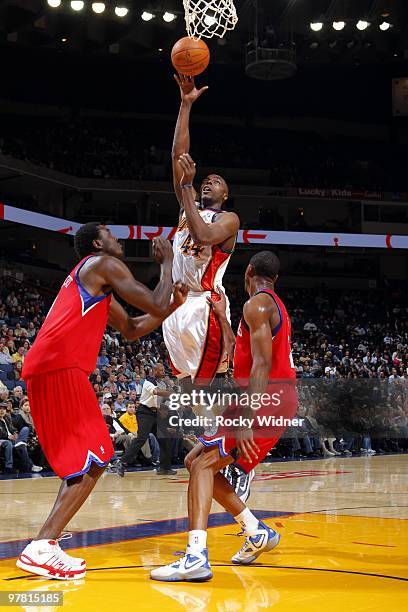 Anthony Tolliver of the Golden State Warriors shoots a layup over Samuel Dalembert and Thaddeus Young of the Philadelphia 76ers during the game at...