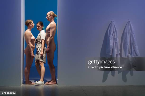 April 2018, Bonn, Germany: A woman enters the reenactment of the performance "Imponderabilia" by walking in between a naked man and a naked woman at...