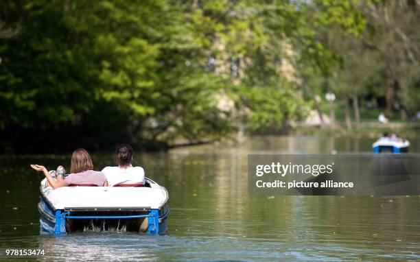 April 2018, Ludwigsburg, Germany: People in pedalos crossing the lake at the Monrepos castle. Photo: Sebastian Gollnow/dpa