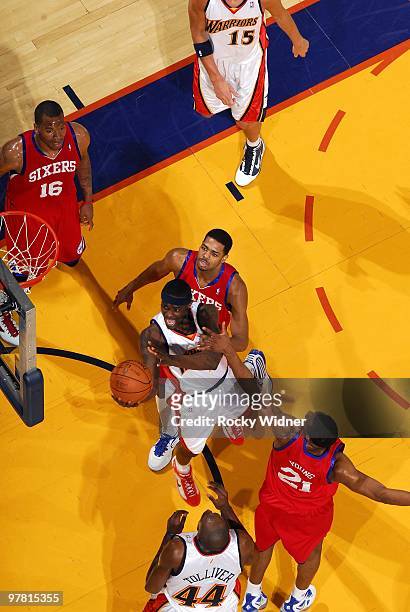 Anthony Morrow of the Golden State Warriors shoots a layup against Rodney Carney and Thaddeus Young of the Philadelphia 76ers during the game at...