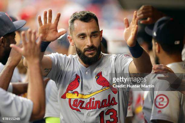 Matt Carpenter of the St. Louis Cardinals high-fives teammates in the dugout after hitting a solo home run in the third inning during a game against...