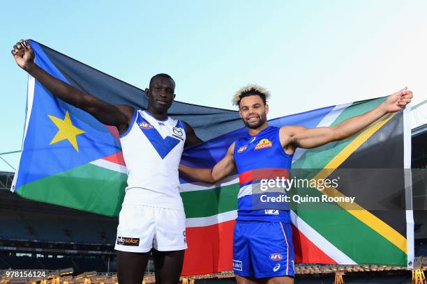 Majak Daw of the Kangaroos and Jason Johannisen of the Bulldogs pose with their national flags during an AFL press conference at Etihad Stadium on...