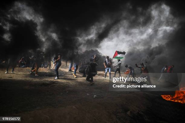 Dpatop - A Palestinian protesters use slings to hurl stones at Israeli security forces during clashes along the Israel-Gaza border, east of Gaza...