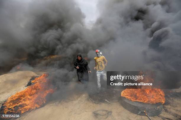 Palestinian protesters burn tyres during clashes with Israeli security forces along the Israel-Gaza border, in Khan Younis, south of the Gaza Strip,...