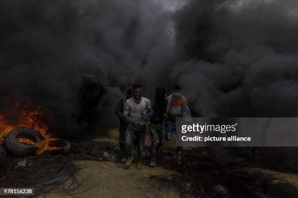 Palestinian protesters burn tyres during clashes with Israeli security forces along the Israel-Gaza border, east of Gaza City, Gaza Strip, 20 April...