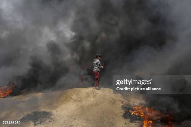 Dpatop - A Palestinian boy holds a sling to hurl stones at Israeli security forces during clashes along the Israel-Gaza border, east of Gaza City,...
