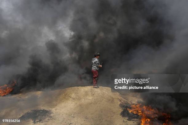 Dpatop - A Palestinian boy holds a sling to hurl stones at Israeli security forces during clashes along the Israel-Gaza border, in Khan Younis, south...