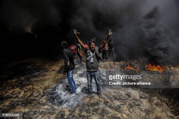 Palestinian protester flashes a victory sign during clashes with Israeli security forces along the Israel-Gaza border, east of Gaza City, Gaza Strip,...