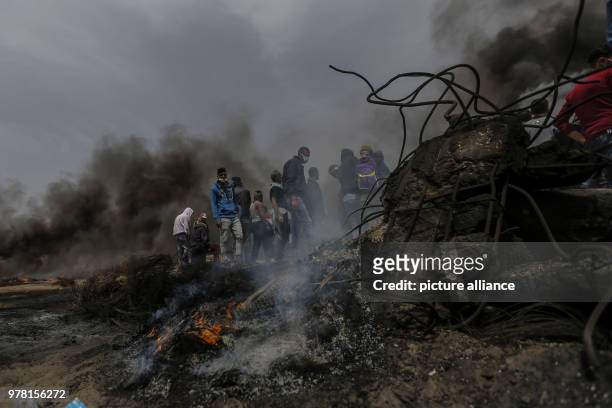 Dpatop - Palestinian protesters burn tyres during clashes with Israeli security forces along the Israel-Gaza border, in Khan Younis, south of the...