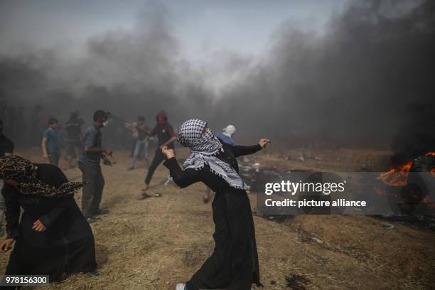 Palestinian woman hurls a stone at Israeli security forces during clashes along the Israel-Gaza border, east of Gaza City, Gaza Strip, 20 April 2018....