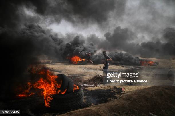 Dpatop - Palestinian protesters hurl stones at Israeli troops during clashes along the Israel-Gaza border, east of Gaza City, Gaza Strip, 20 April...