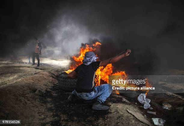 Dpatop - A Palestinian protester uses a sling to hurl stones at Israeli security forces during clashes along the Israel-Gaza border, in Khan Younis,...