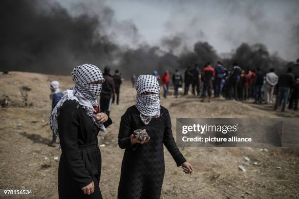 Dpatop - Palestinian women hold stones to hurl at Israeli security forces during clashes along the Israel-Gaza border, east of Gaza City, Gaza Strip,...