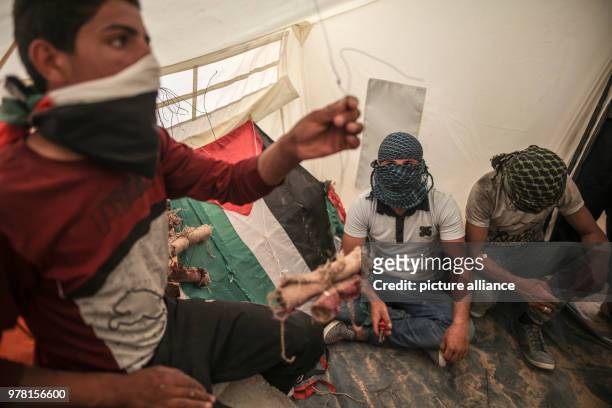 Dpatop - Palestinian protesters prepare kites with home made firebombs during clashes along the Israel-Gaza border, east of Gaza City, Gaza Strip, 20...