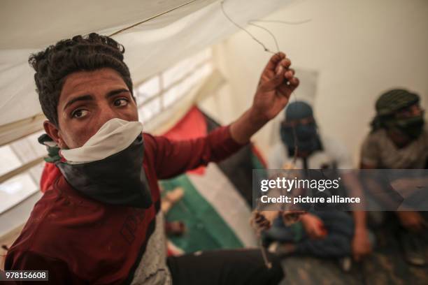 Dpatop - Palestinian protesters prepare kites with home made firebombs during clashes along the Israel-Gaza border, east of Gaza City, Gaza Strip, 20...