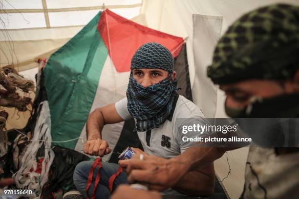 Dpatop - Palestinian protesters prepare kites with home made firebombs during clashes along the Israel-Gaza border, east of Gaza City, Gaza Strip, 20...