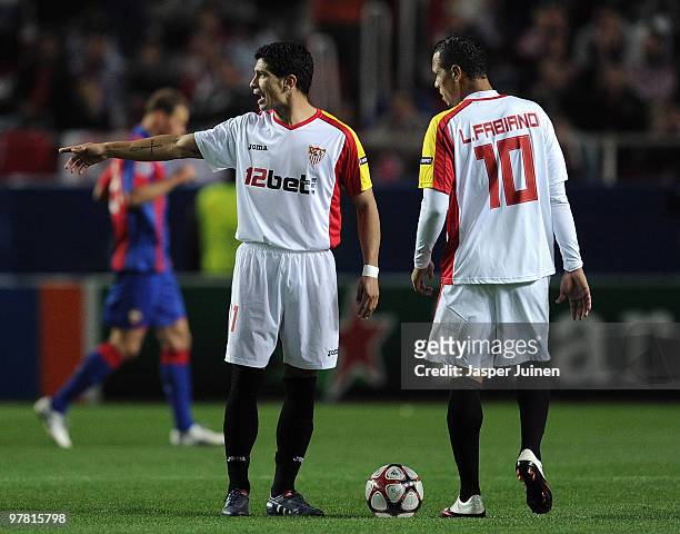 Diego Perotti of Sevilla stands with Luis Fabiano waiting to resume their game after conceding a goal during the UEFA Champions League round of...
