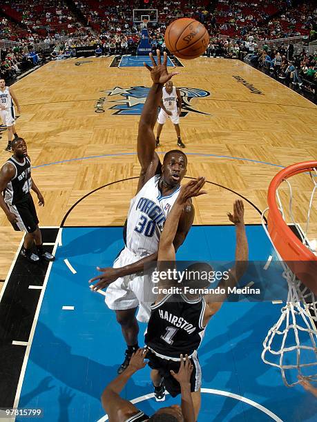 Brandon Bass of the Orlando Magic shoots a hook shot against Malik Hairston of the San Antonio Spurs during the game on March 17, 2010 at Amway Arena...