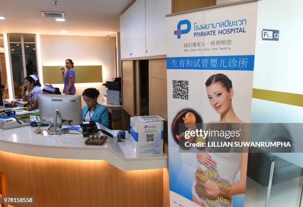 This photo taken on May 17, 2018 shows a poster in Chinese promoting in vitro fertilisation displayed in the lobby of Piyavate Hospital in Bangkok...
