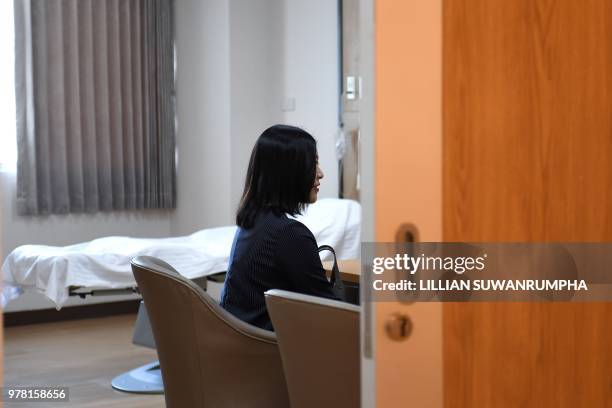 This photo taken on May 17, 2018 shows Chinese wife Xu Mengsha accompanied by husband Zhang Yinzhe speaks to a Thai fertility physician at the...