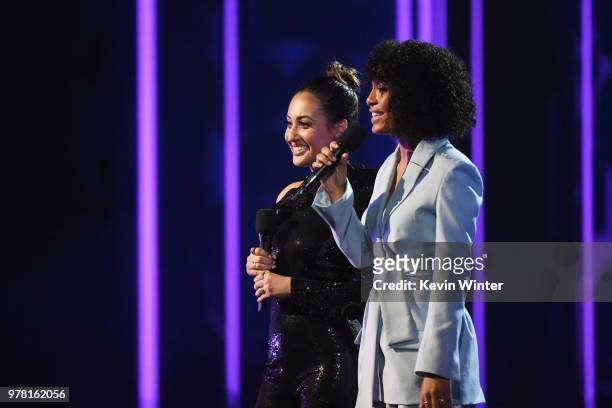 Actors Francia Raisa and Yara Shahidi speak onstage during the 2018 MTV Movie And TV Awards at Barker Hangar on June 16, 2018 in Santa Monica,...