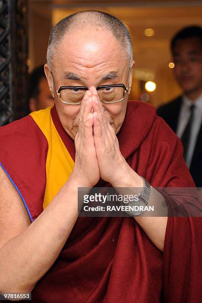 Tibetan spitirual leader The Dalai Lama gestures to an audience during the book presentation of 'Tibet Fifty Years After' in New Delhi on March 18,...