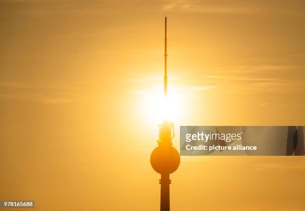 April 2018, Germany, Berlin: The sun sets behind the Berlin television tower. Photo: Christophe Gateau/dpa