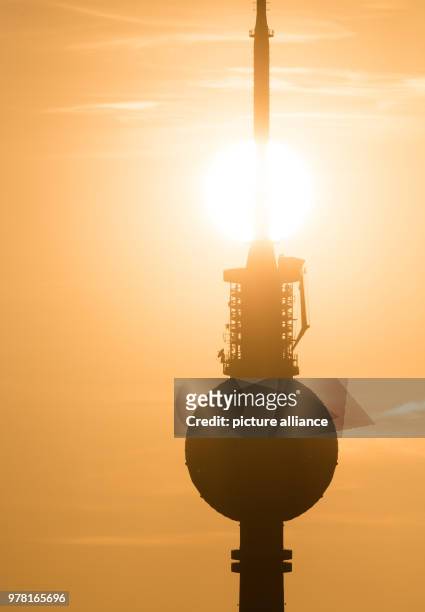 April 2018, Germany, Berlin: The sun sets behind the Berlin television tower. Photo: Christophe Gateau/dpa