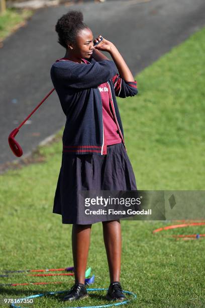 Christella Rukiza watches her ball in golf during the Olympic Refugee Sport Day at The Trusts Arena on June 19, 2018 in Auckland, New Zealand. The...