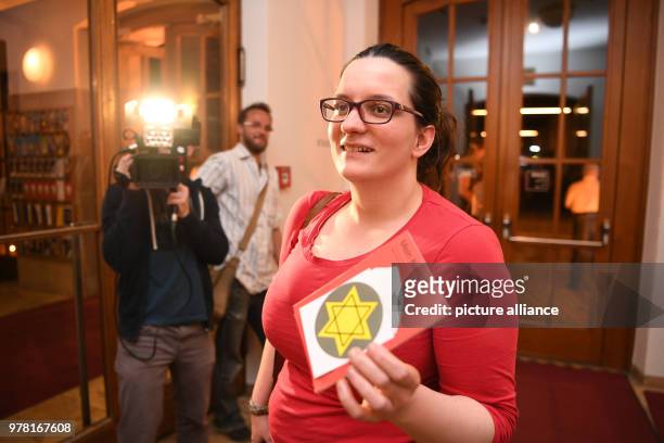 April 2018, Germany, Konstanz: Student Sophie Arzt holding a Star of David and the booklet for the play after the premiere of the play "Mein Kampf"...