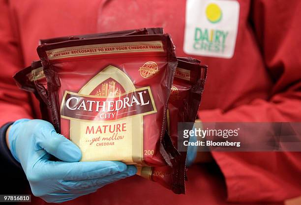 An employee holds packets of Cathedral City cheese packaged at Dairy Crest's factory in Nuneaton, U.K., on Wednesday, March 17, 2010. Dairy Crest...