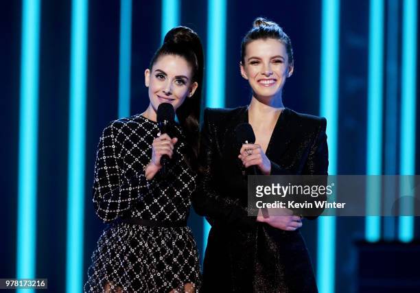 Actors Alison Brie and Betty Gilpin speak onstage during the 2018 MTV Movie And TV Awards at Barker Hangar on June 16, 2018 in Santa Monica,...