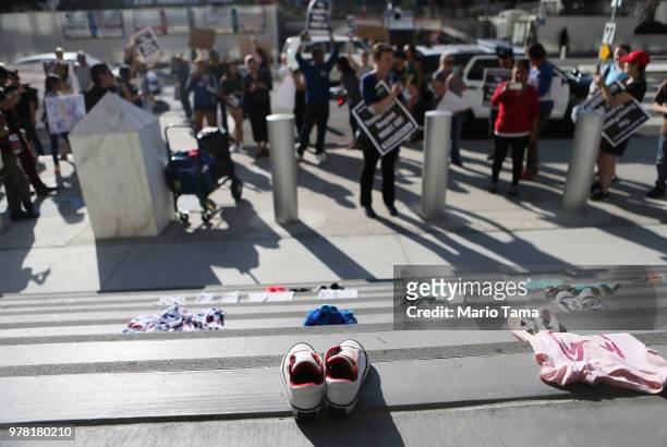 Protestors demonstrate against the separation of migrant children from their families in front of clothes representing migrant children on June 18,...