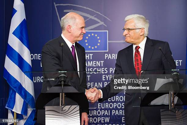 Jerzy Buzek, president of the European Parliament, right, greets George Papandreou, Greece's prime minister, during their press briefing at the...