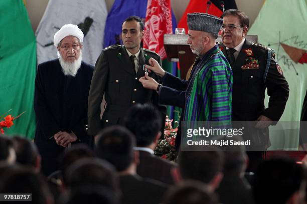 Afghan President Hamid Karzai pins a medallion on a graduating officer's uniform during a graduation ceremony for Afghan National Army officers at...
