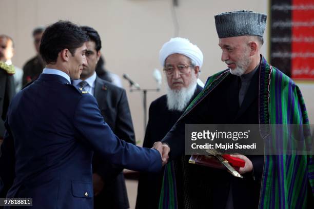 Afghan President Hamid Karzai shakes hands with a graduating officer during a graduation ceremony for Afghan National Army officers at the ANA...