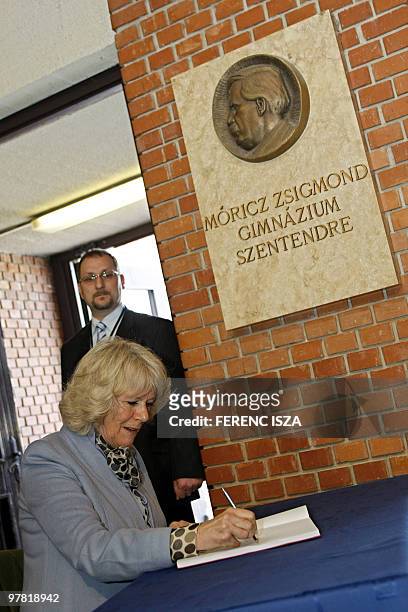 Camilla, wife of Britain's Prince Charles signs the visitors book at the 'Moricz Zsigmond' Secondary School in Szentendre on March 17, 2010. Prince...